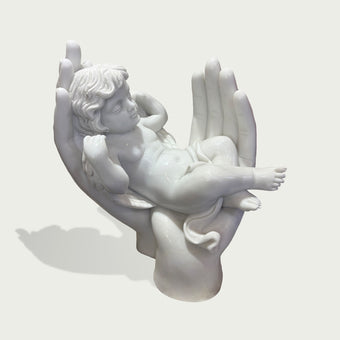 Sleeping Angel In Hands Natural Marble Statue on a hand against a light gray background