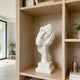 Fragmented Face Marble Sculpture on a wooden shelf in a modern room