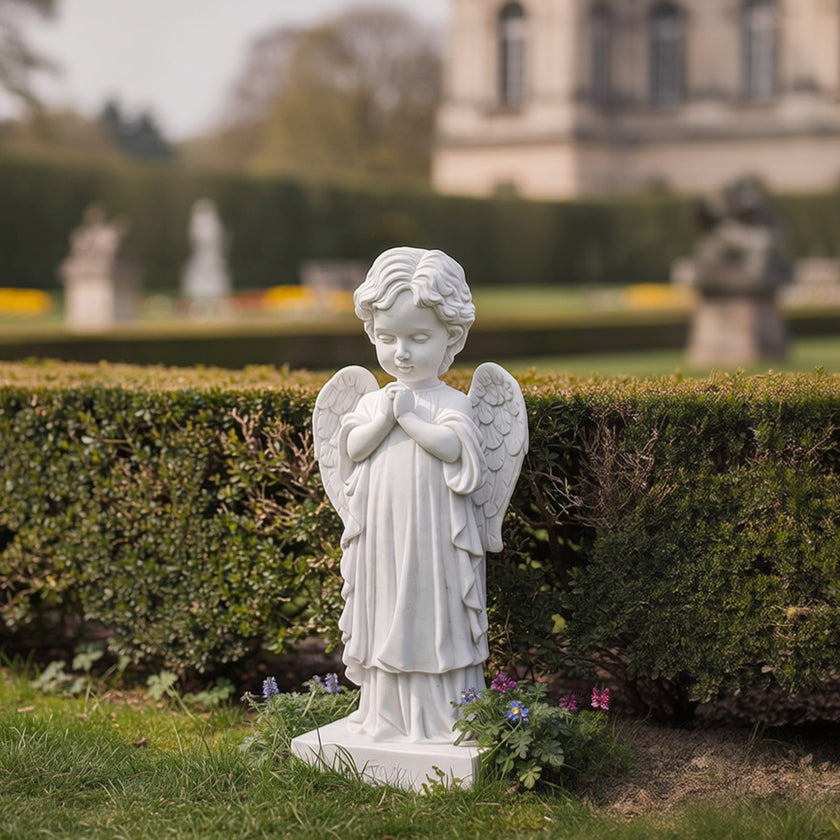 Gentle Praying Cherub Marble Sculpture in a garden setting with blurred background