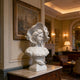 Vintage Lady Marble Bust Statue in an elegant room with artwork and furniture.