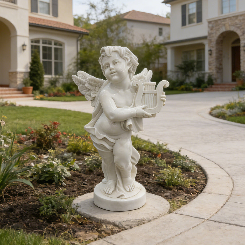 White marble cherub angel statue holding a lyre, displayed in a villa garden with lawn, flowers, and luxury home background.