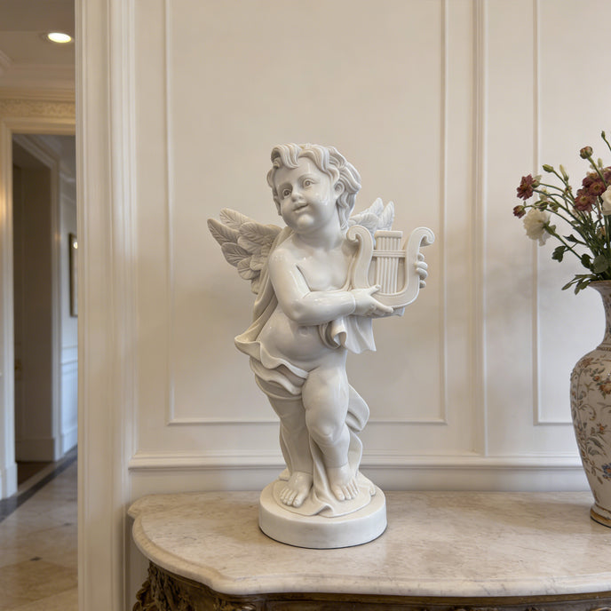 White marble cherub angel lyre statue placed on an indoor console table, adding classic charm to an elegant home entryway.