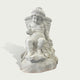 Natural white marble seated child sculpture with basket texture, fruit carving, soft drapery, and gentle downward gaze on a clean background.