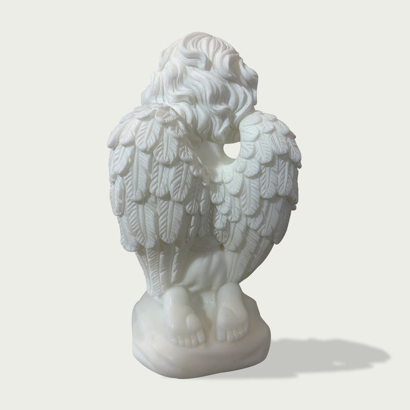 Back view of white marble praying angel sculpture showing detailed feather wings, carved hair texture, and kneeling pose on a clean background.