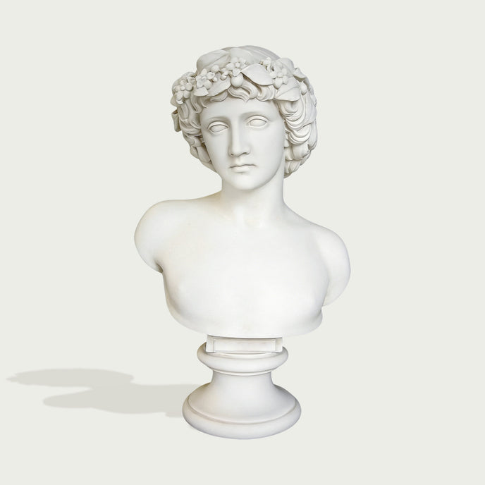 Natural white marble male bust sculpture with floral crown, classical face, smooth shoulders, and pedestal display on a clean background.