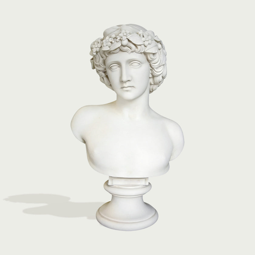 Natural white marble male bust sculpture with floral crown, classical face, smooth shoulders, and pedestal display on a clean background.