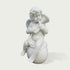 A white marble-style sculpture of a cherub or cupid sitting on a round base, holding a small flute, shown against a plain light gray background.