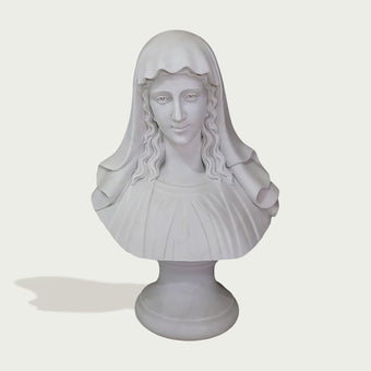 A white classical-style bust sculpture of a woman with long wavy hair and a draped veil, mounted on a round pedestal against a light gray background.