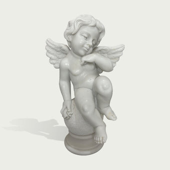 Hand carved white marble cherub sculpture with peaceful expression, delicate wings, and smooth polished stone finish