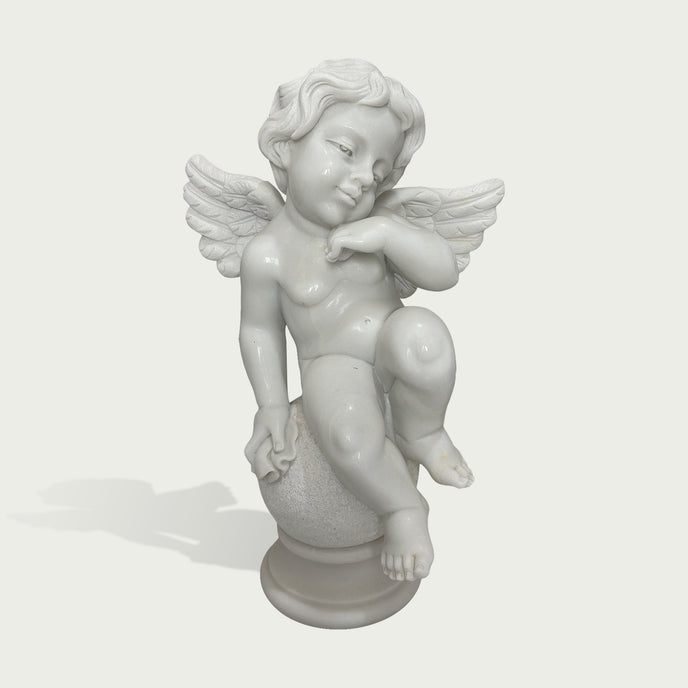 Hand carved white marble cherub sculpture with peaceful expression, delicate wings, and smooth polished stone finish