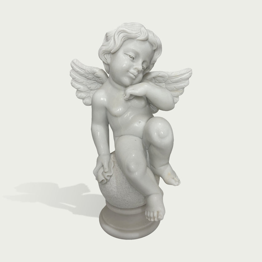 Hand carved white marble cherub sculpture with peaceful expression, delicate wings, and smooth polished stone finish