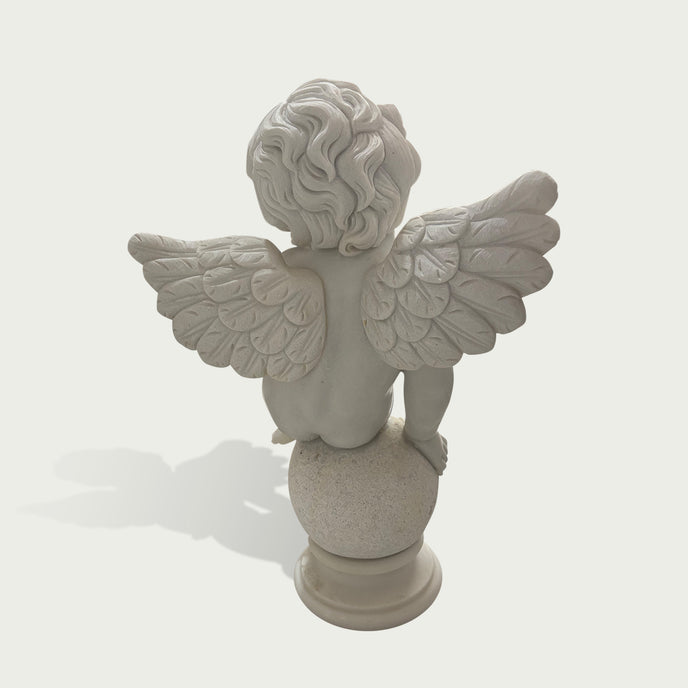 Back view of a white marble cherub angel sculpture showing detailed feathered wings and handcrafted stone carving