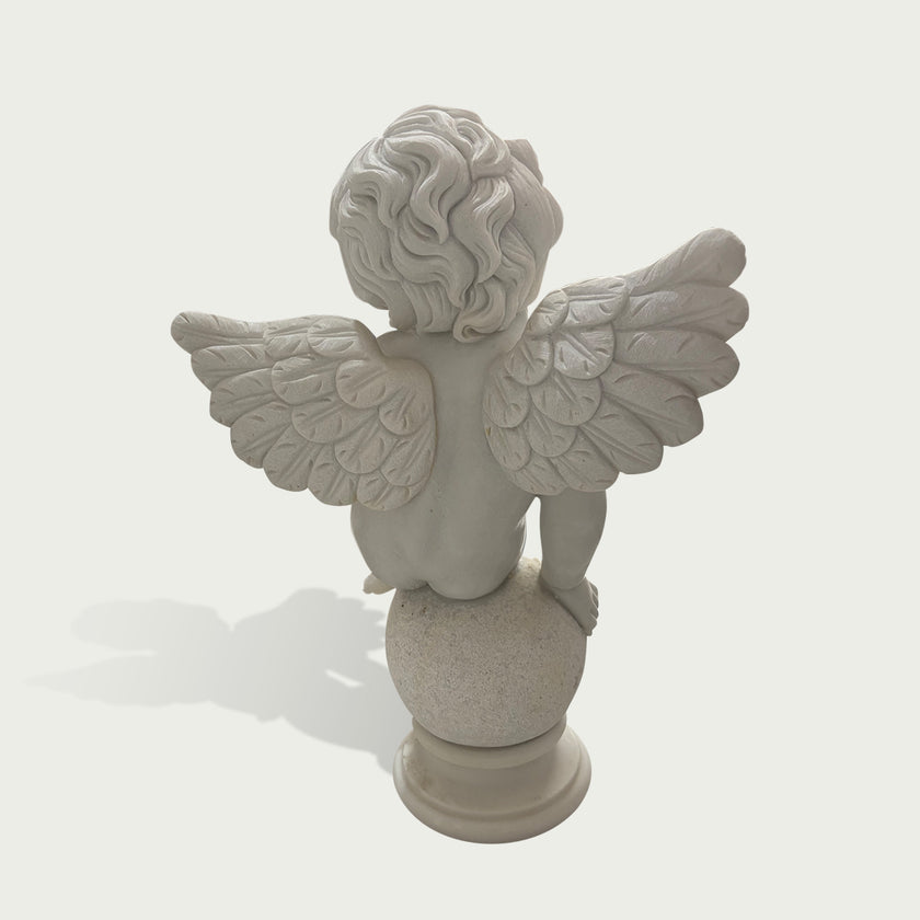 Back view of a white marble cherub angel sculpture showing detailed feathered wings and handcrafted stone carving