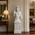 White marble Roman warrior bust displayed in a luxury interior with classical decor and elegant pedestal setting.