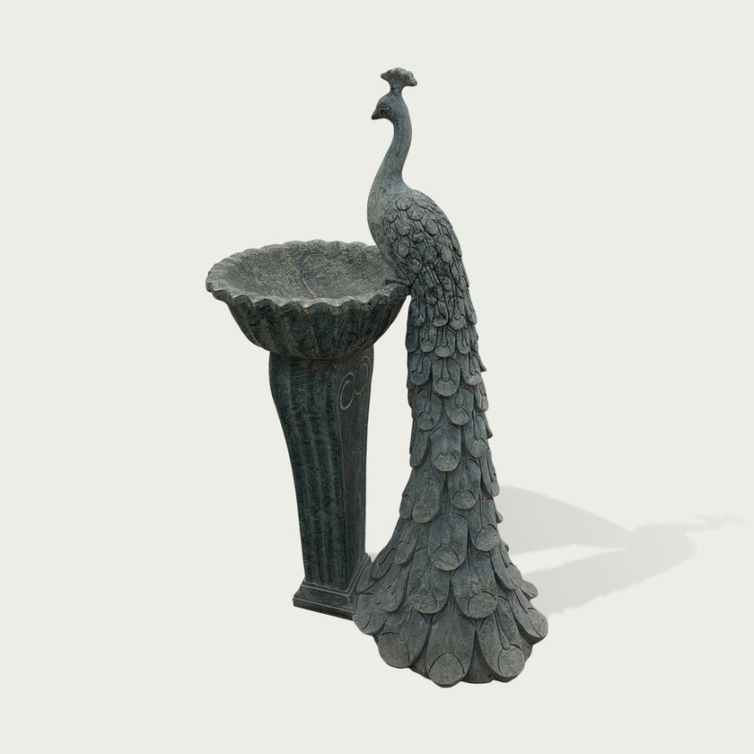 Side view of elegant peacock fountain sculpture with long detailed tail and decorative pedestal for luxury garden landscaping