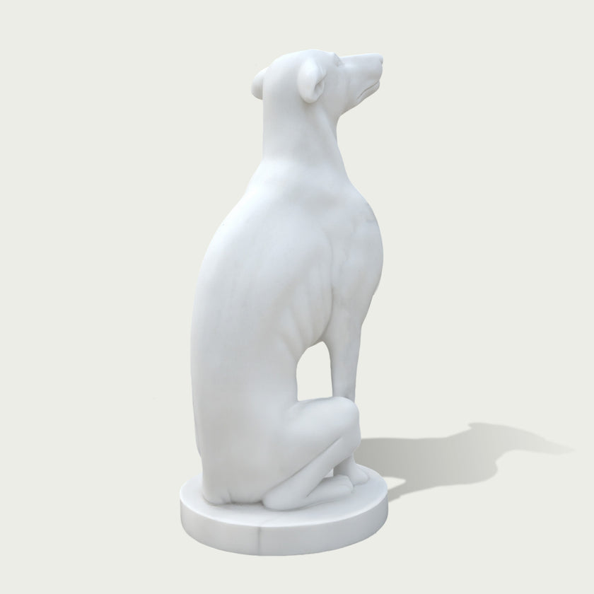 Back view of a white marble greyhound statue displaying smooth curves, detailed form, and handcrafted stone sculpture quality.