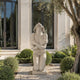 White marble kneeling female statue displayed outdoors with modern architecture and refined classical sculpture design