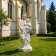 White marble Virgin Mary and Child Jesus statue displayed outdoors near a church, featuring elegant carved details, traditional Catholic artwork, and garden setting