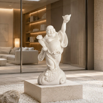 White jade Laughing Buddha statue with joyful expression, raised hand holding ingot and detailed robe carvings, displayed in a modern luxury interior setting