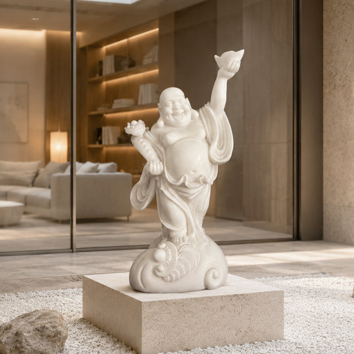 White jade Laughing Buddha statue with joyful expression, raised hand holding ingot and detailed robe carvings, displayed in a modern luxury interior setting