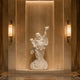White marble Laughing Buddha sculpture placed in an elegant indoor alcove, featuring a smiling figure, flowing robes and traditional prosperity symbolism