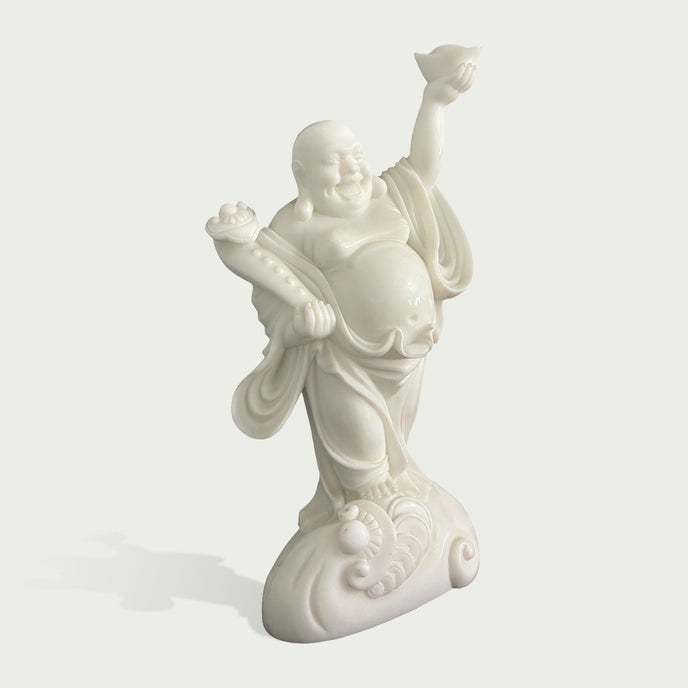 Side angle view of white stone Laughing Buddha sculpture showing detailed robe folds, balanced pose, expressive face and artistic carved pedestal design