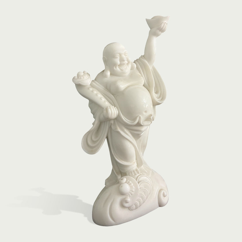Side angle view of white stone Laughing Buddha sculpture showing detailed robe folds, balanced pose, expressive face and artistic carved pedestal design
