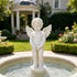 White marble cherub angel fountain statue displayed in a garden setting, with detailed wings, standing pose, and water feature design for outdoor decoration.