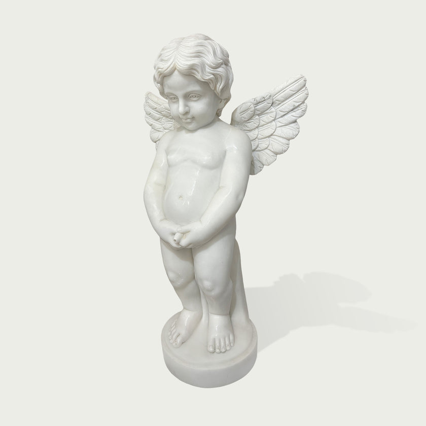 Front view of a white marble angel child sculpture with feathered wings, smooth carved details, rounded base, and peaceful classical decorative style.