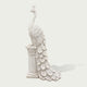 Side view of a classical white marble peacock sculpture on a stone pedestal, showing detailed feather patterns, long tail, and handcrafted stone texture.