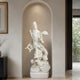 White marble Guanyin Bodhisattva sculpture with dragon and cloud motifs placed in a modern wall niche, showcasing fine craftsmanship and spiritual art design.