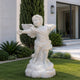 White marble cupid angel statue displayed outdoors in a luxury garden setting, featuring carved wings, youthful figure, and smooth polished marble surface.