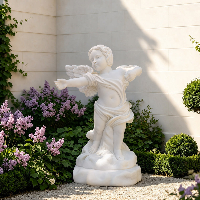 Side view of a white marble cherub statue showing intricate feathered wings, flowing fabric details, and handcrafted classical sculpture craftsmanship.