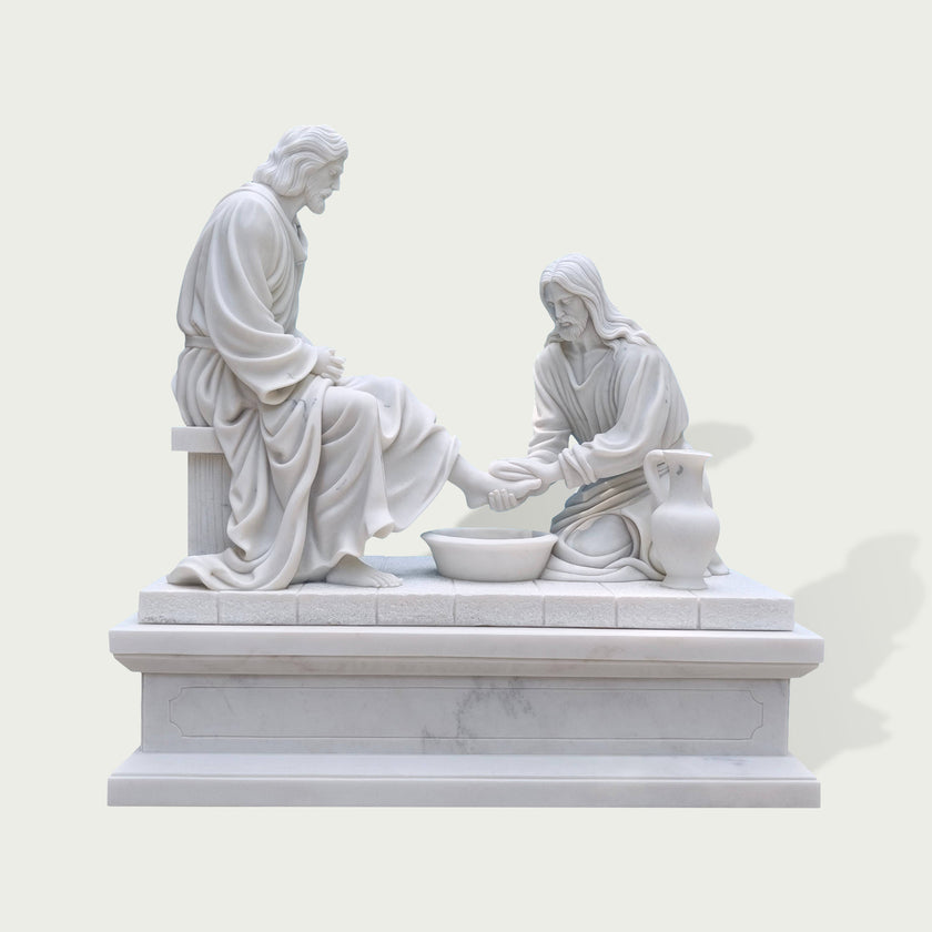 Front view of a white marble Christ washing feet statue with detailed drapery, seated figure, kneeling disciple, and handcrafted religious sculpture design.