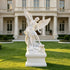 White marble Saint Michael the Archangel garden sculpture displayed outdoors, featuring dramatic wings, sword, dragon base and elegant architectural setting.