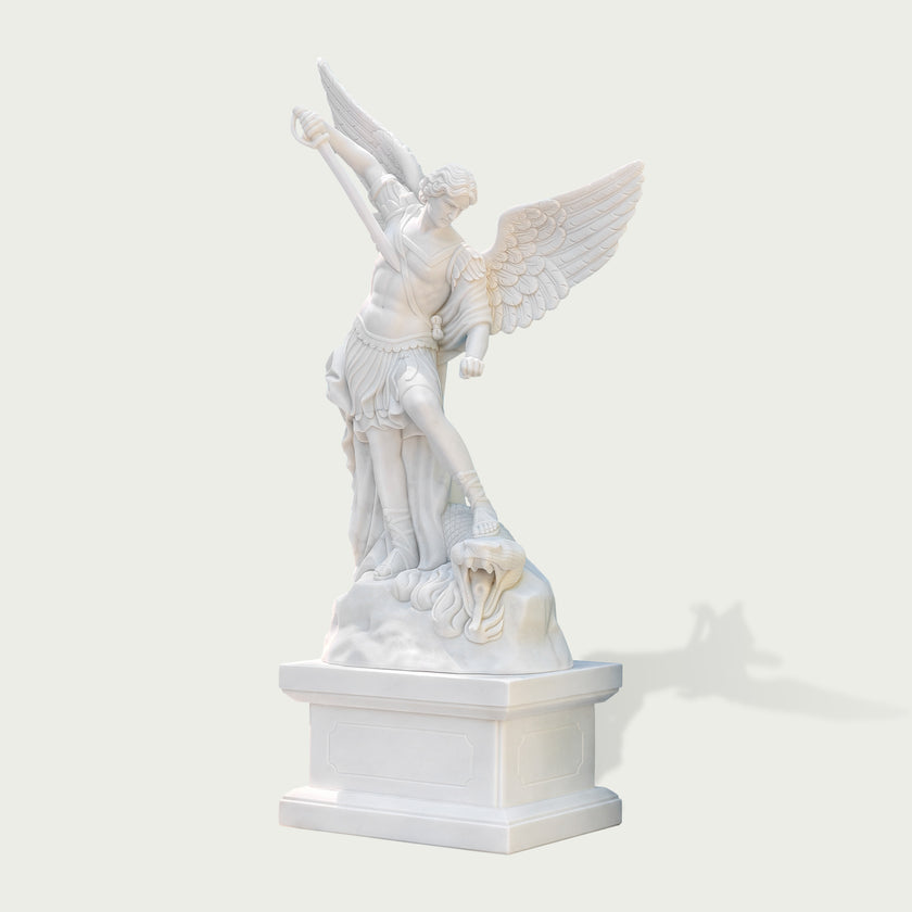 Three-quarter view of a polished white marble Archangel Michael sculpture standing on pedestal with detailed wings, robe folds and carved dragon figure.