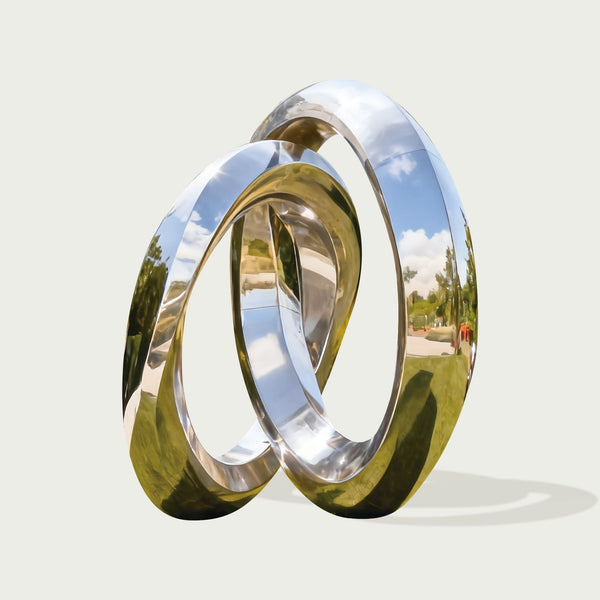  interlocking silver rings stainless steel sculpture with a reflective surface, showing a scenic reflection.