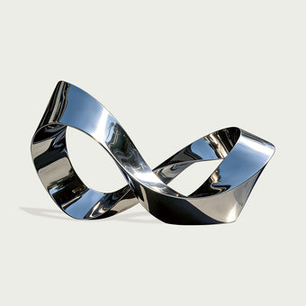 Modern silver stainless steel mirro polished sculpture Infinite Loop in front of a glass building