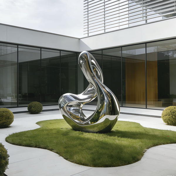 Stainless Steel Modern silver sculpture in a garden setting with a contemporary building in the background