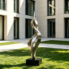 Soaring Ribbon Twisting Stainless Steel Sculpture on grass in front of a modern building