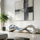 Modern Stainless Steel silver bench sculpture in a stylish living room with abstract art and plant.