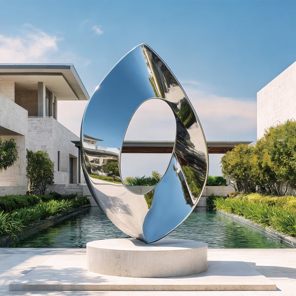 Modern stainless steel silver luminous portal sculpture in a garden setting with a building and pool in the background