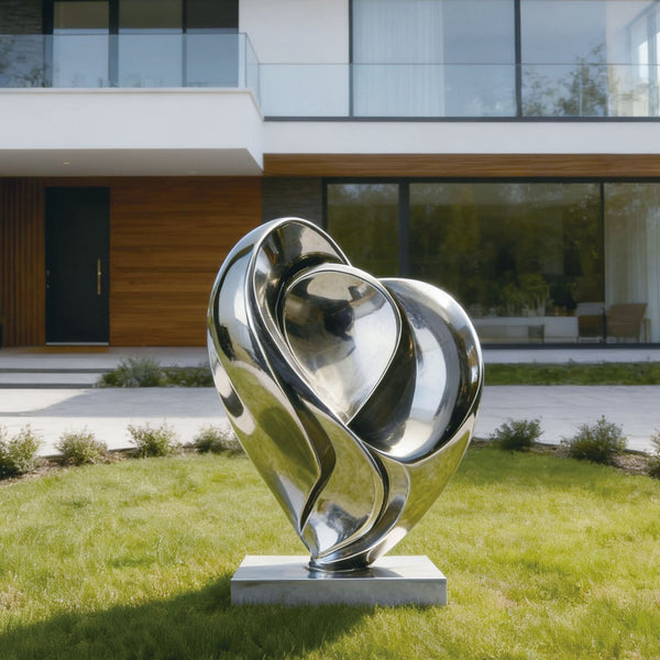 Modern stainless steel silver blooming heart sculpture in front of a contemporary house