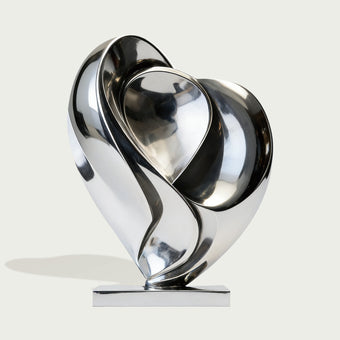 Modern stainless steel silver blooming heart sculpture on a white background