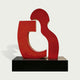 Contemporary Red Puzzle Abstract Stainless Steel Sculpture on a black base against a white background