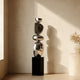 Stainless Steel Irregular Balancing Floor Sculpture in a corner of a minimalist living room 