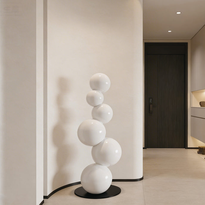 Abstract Floating White Balls Stainless Steel Sculpture  against a neutral wall.