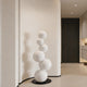 Abstract Floating White Balls Stainless Steel Sculpture  against a neutral wall.