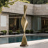 wisted Column Garden Bronze Sculpture  by a poolside with modern building in the background