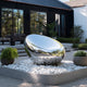 Mirror Polished Oval Egg Stainless Steel Sculpture  in a garden setting with modern house in the background